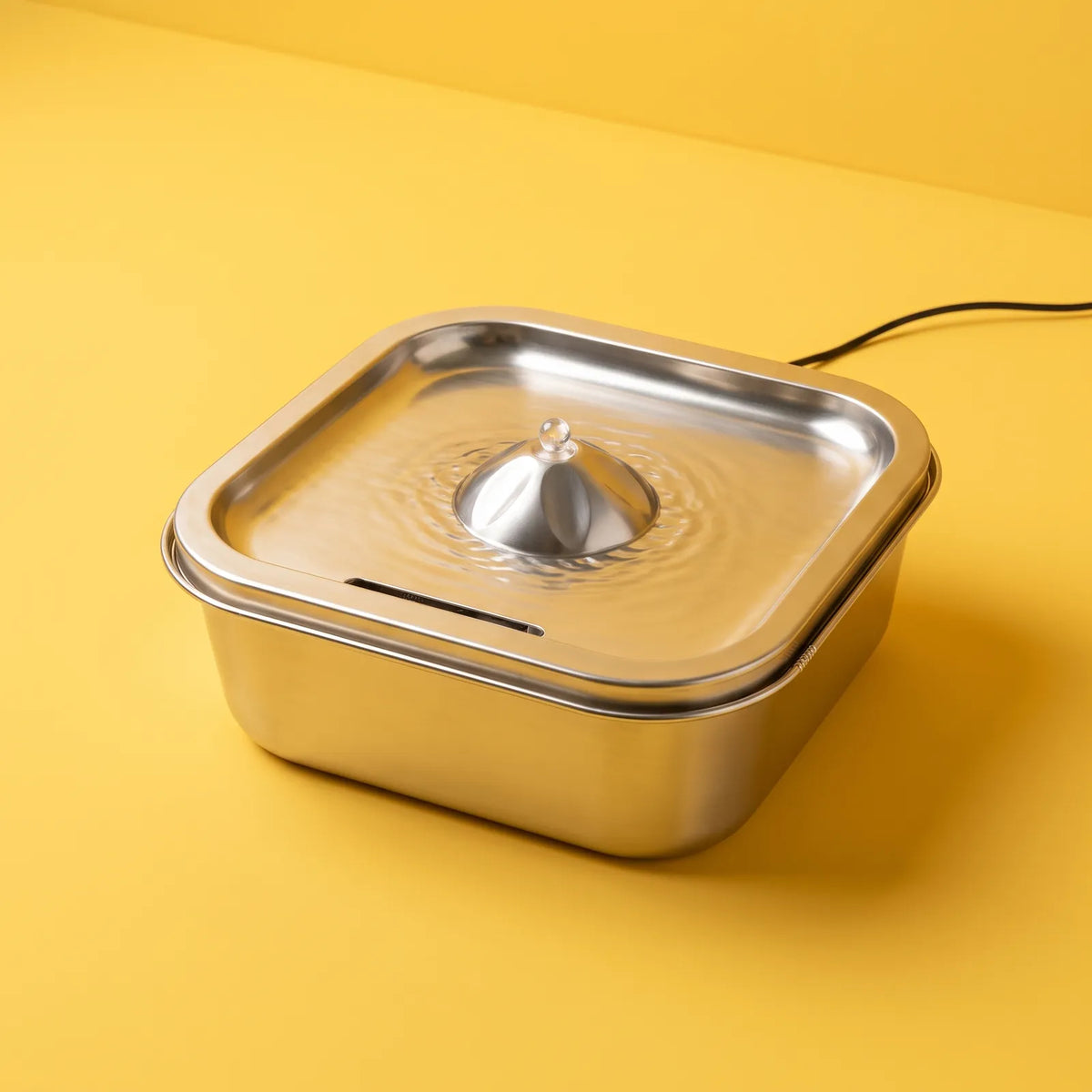 Fontaine Fontaline en inox sur fond jaune, vue de trois quarts. Image générée par IA.